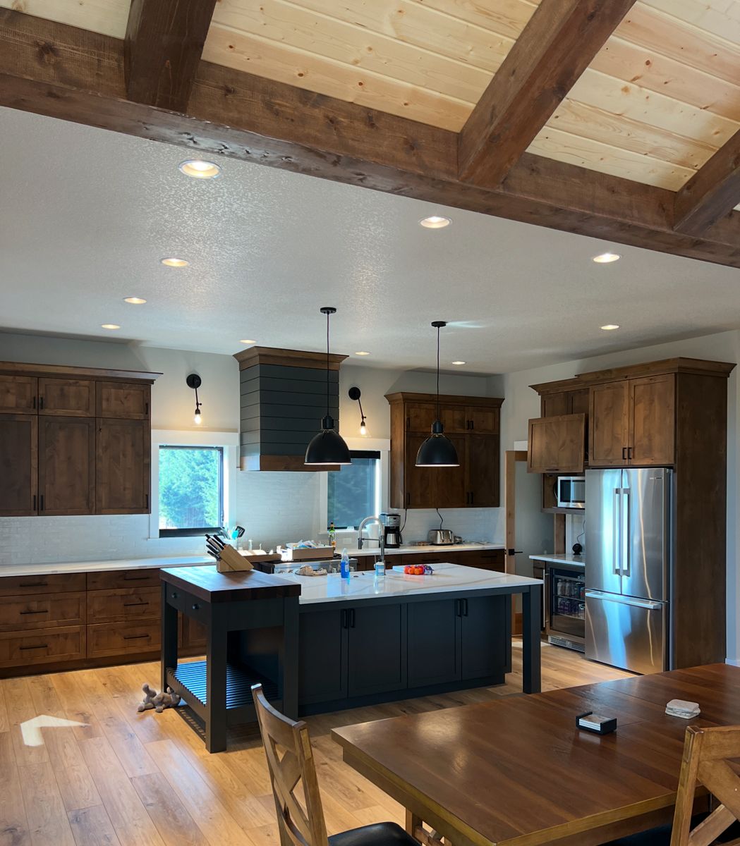 Rustic alder kitchen with black island and shiplap hood
